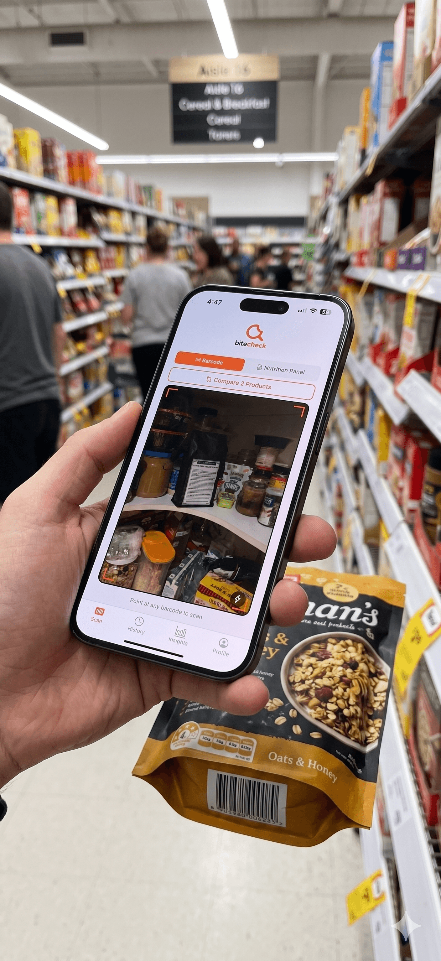 A hand holds a smartphone scanning a granola bag barcode with the Bitecheck app.